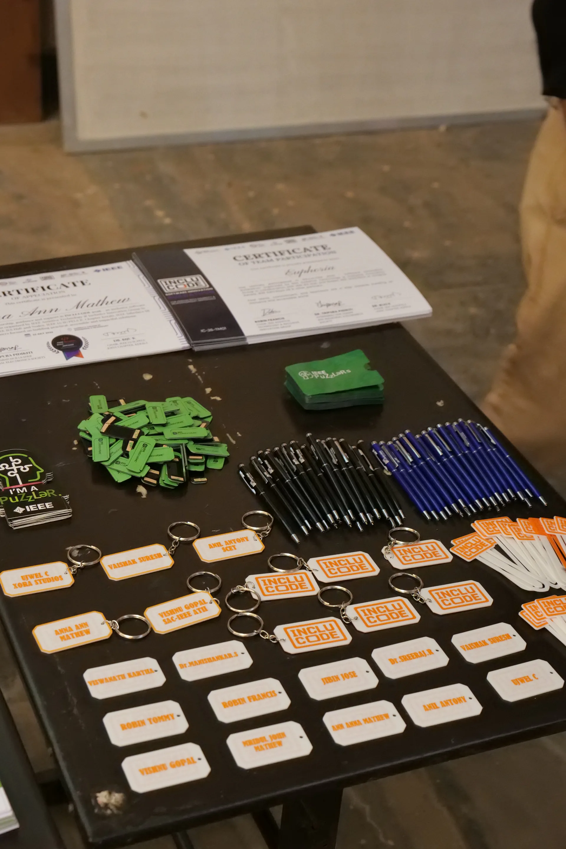INCLUCODE 2026 certificates, USB drives, pens, keychains, and participant name tags