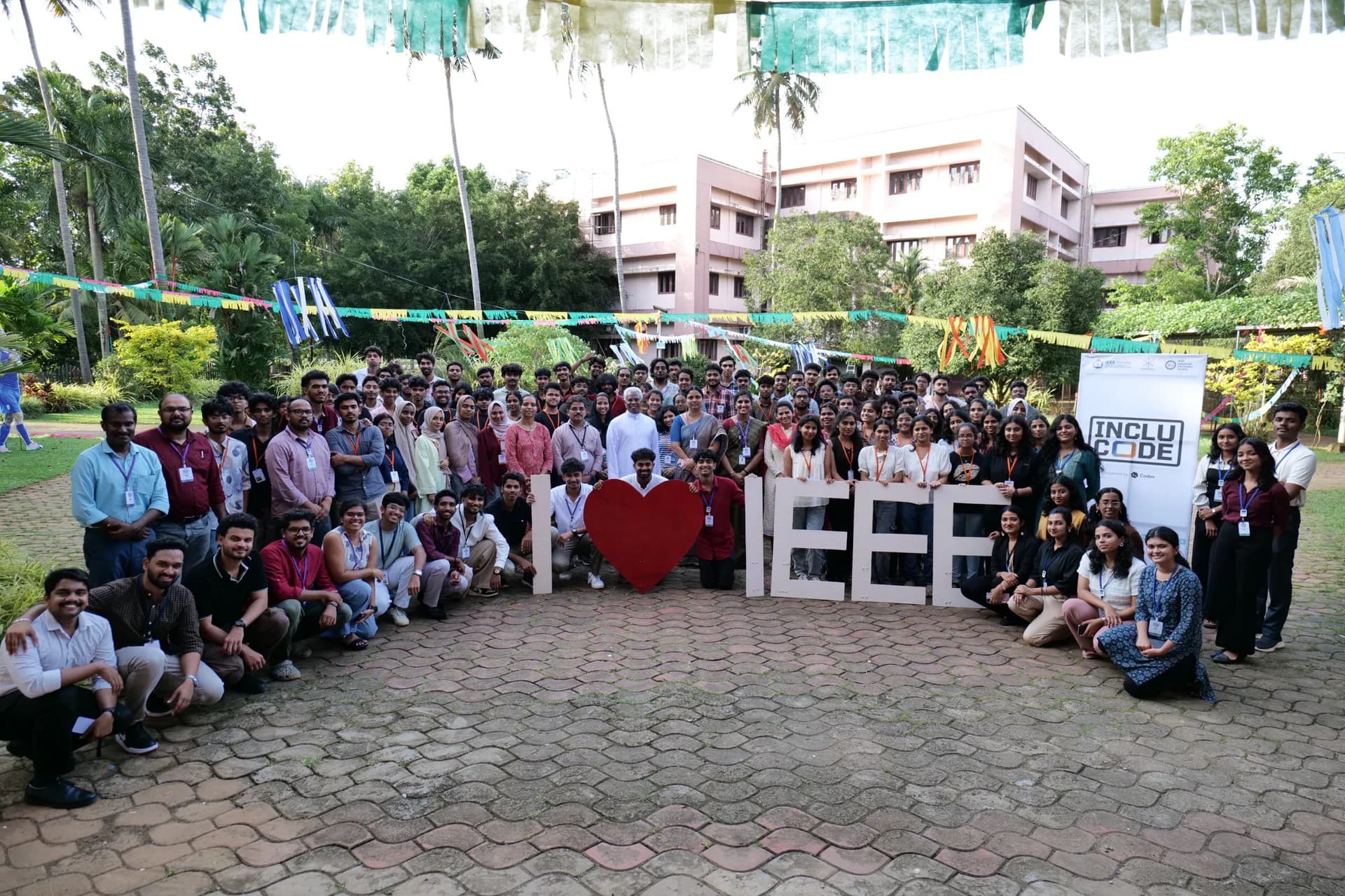 INCLUCODE 2026 participants, mentors, and organizers gathered outdoors with the event banner