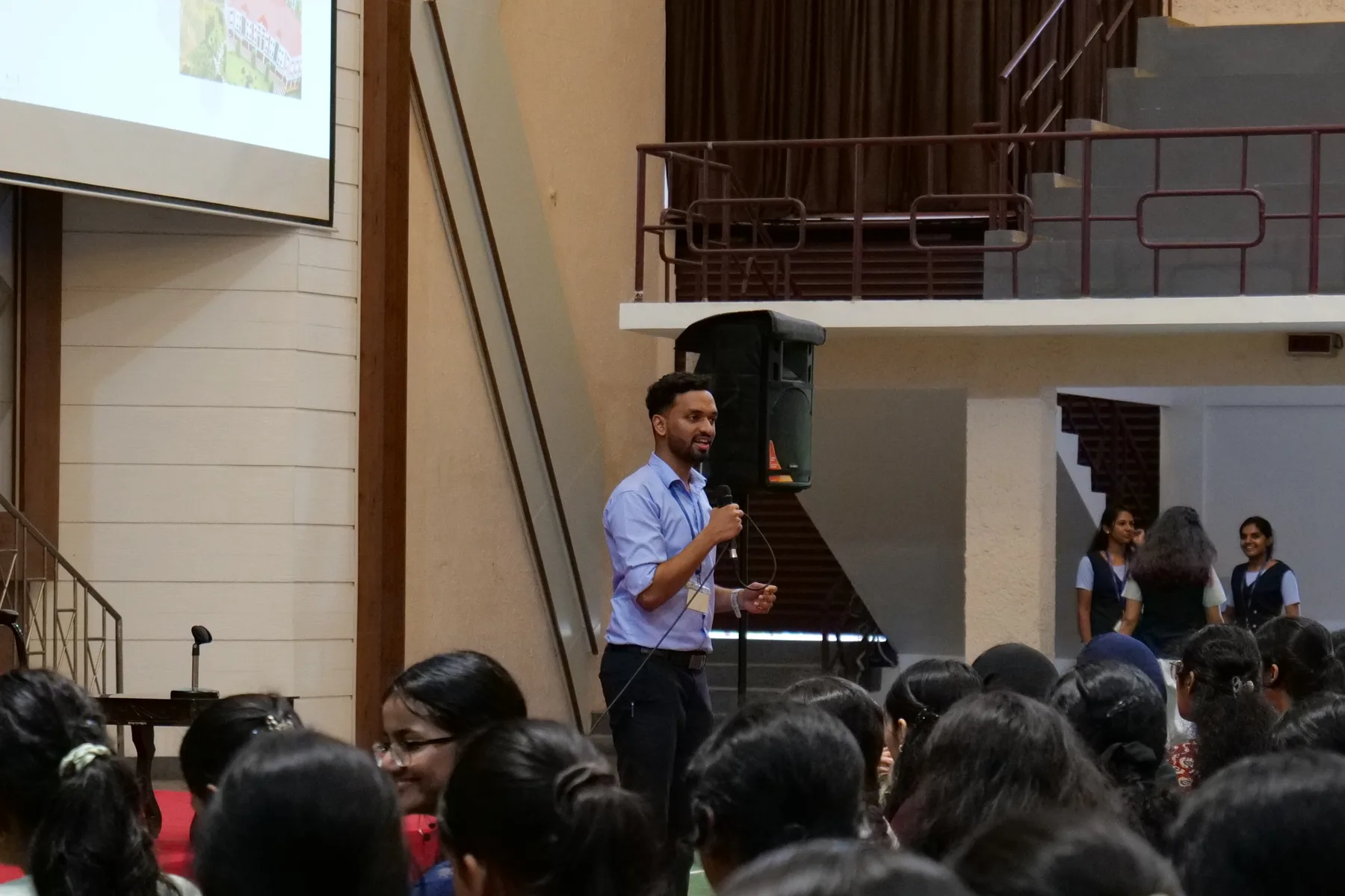 Robin Francis speaking with a microphone to students in an auditorium