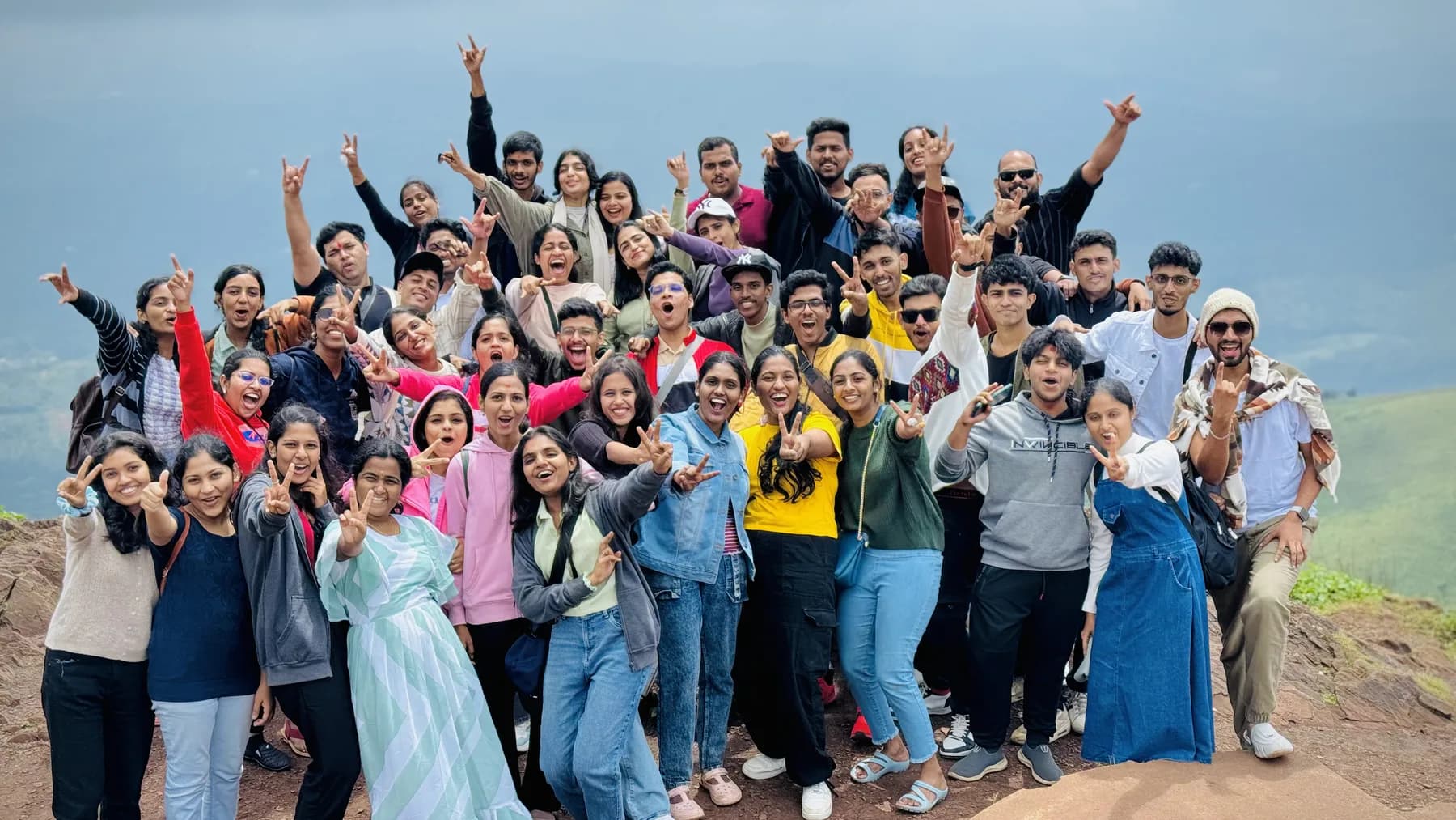 Large community group celebrating outdoors on a hilltop