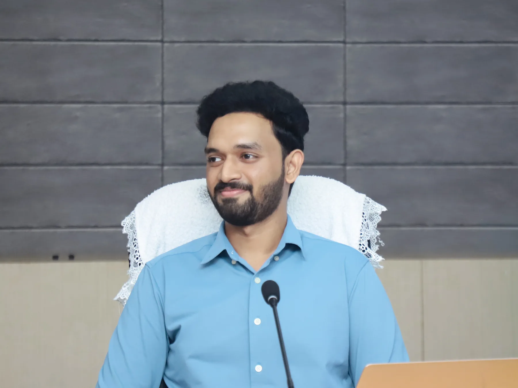Robin Francis seated at a microphone during a Sahrdaya meeting