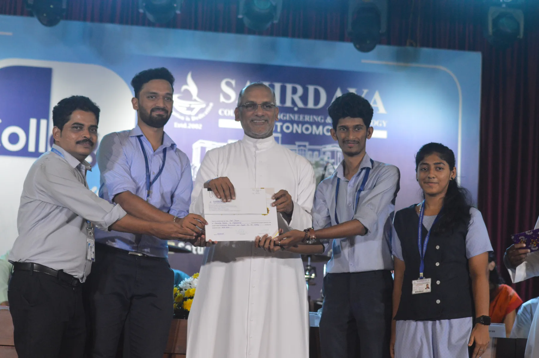 Robin Francis and teammates receiving a certificate on the Sahrdaya stage