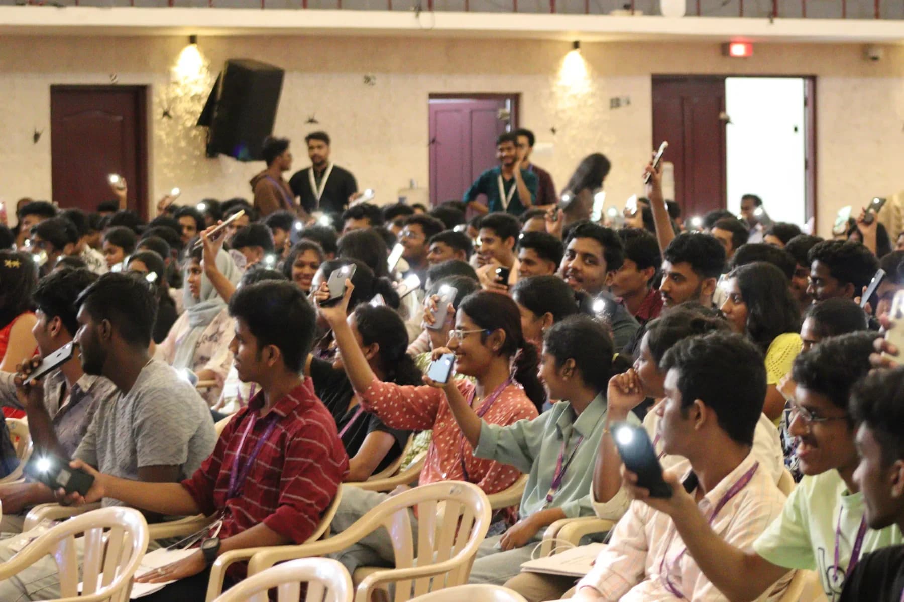 TechX Infinia audience holding up lit phone torches during the flagship event. Robin Francis project