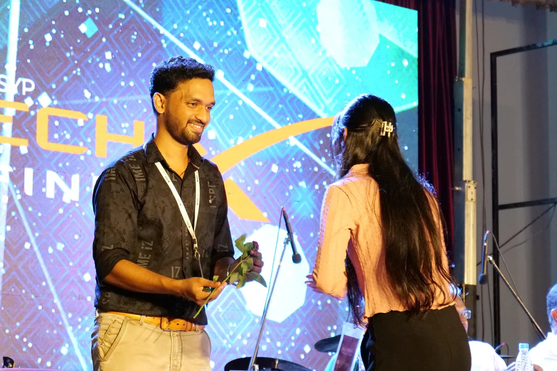 Robin Francis receiving a rose on the TechX Infinia stage