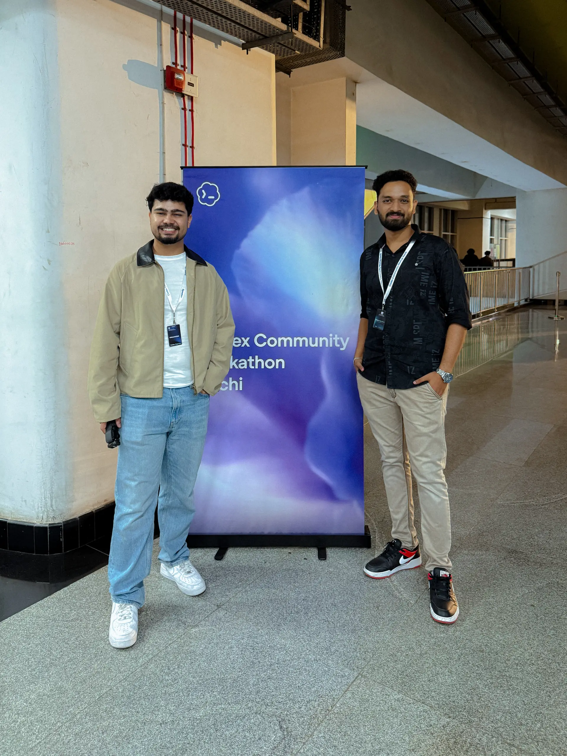 Robin Francis with a fellow organizer beside the Codex Community Hackathon Kochi banner