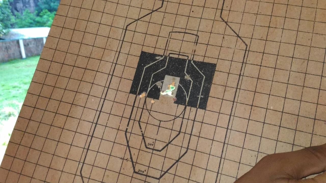A .22 rifle target sheet showing the grouping of fired rounds around the centre